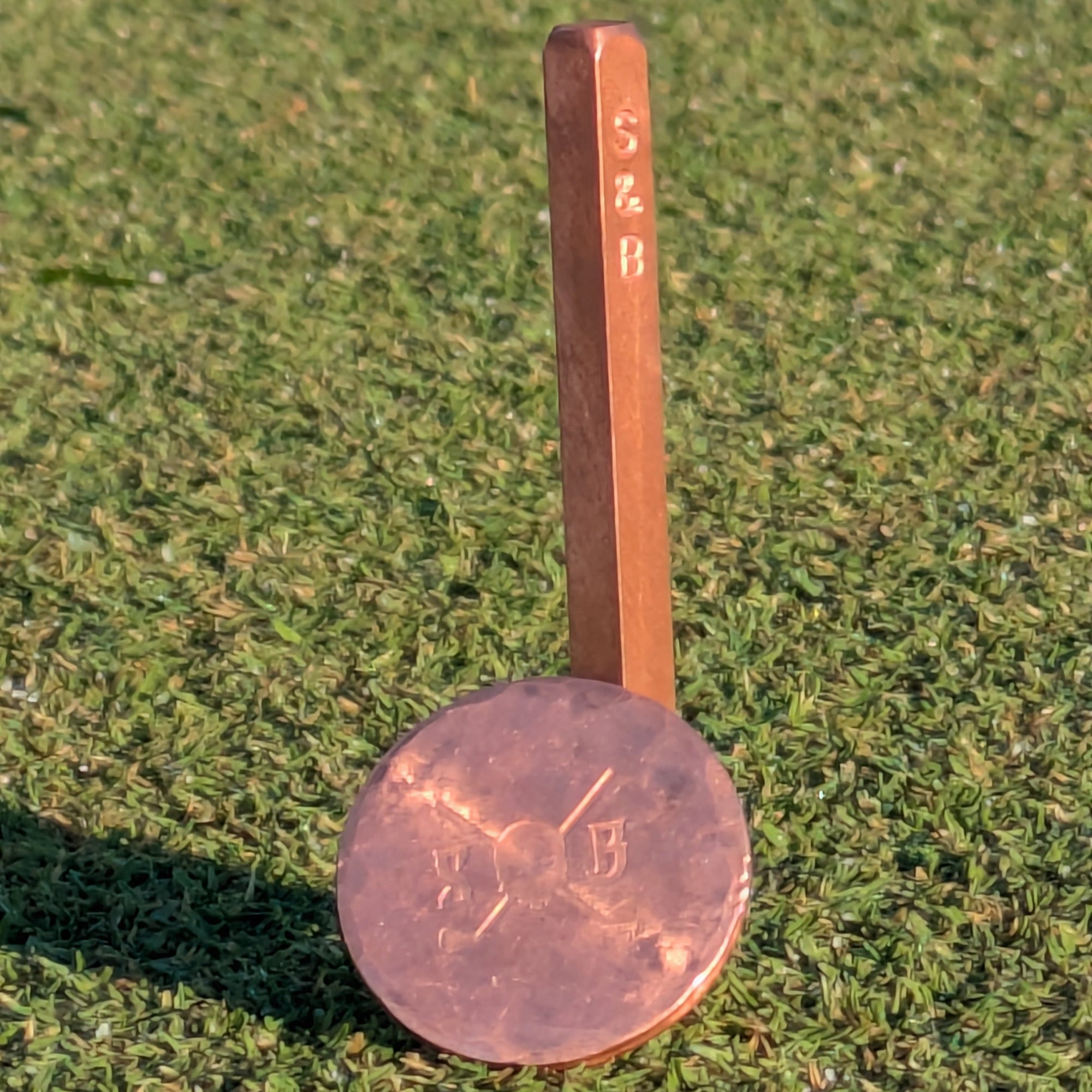 Copper measuring spoon on a grassy background