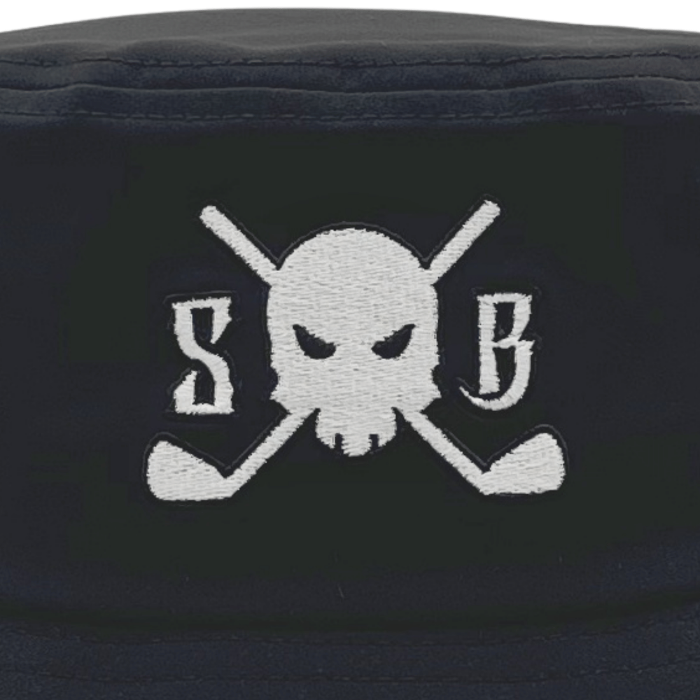 Close-up of a black bucket hat featuring a white embroidered skull and crossed golf clubs with the letters 'S' and 'B' on either side.