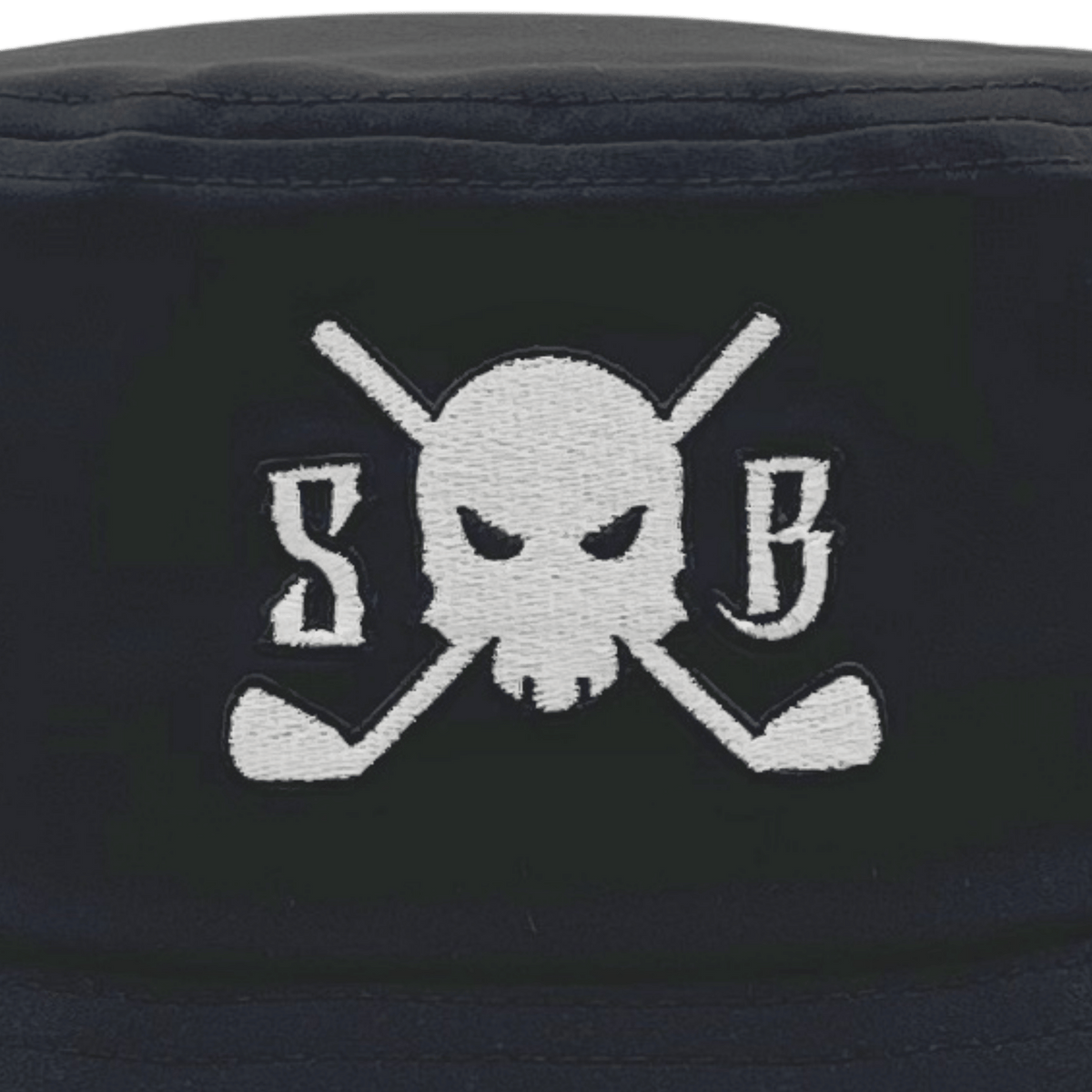 Close-up of a black bucket hat featuring a white embroidered skull and crossed golf clubs with the letters 'S' and 'B' on either side.