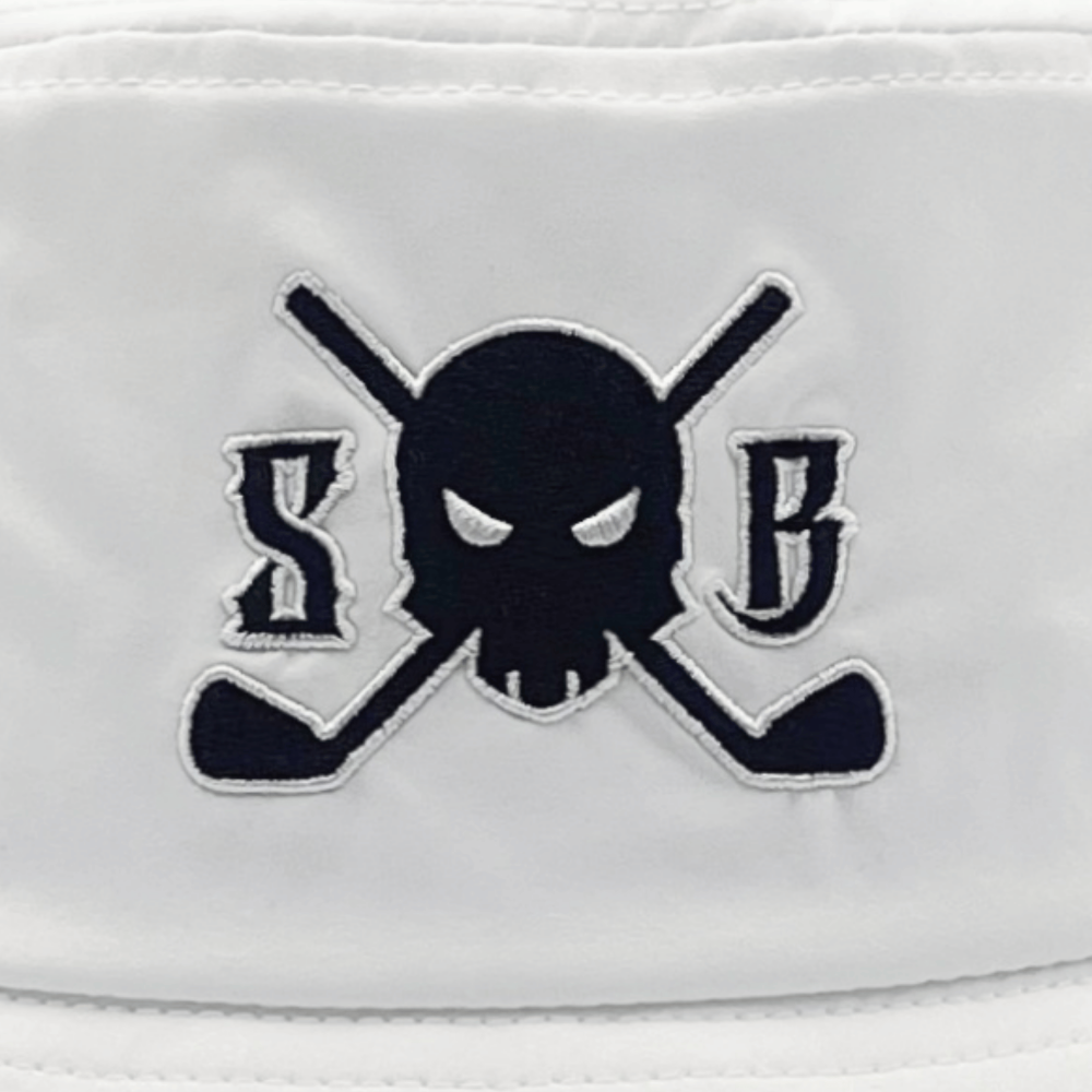 A close-up of a white fabric item featuring an embroidered logo of a black skull with white eyes, flanked by the letters 'S' and 'B' on a background of crossed golf clubs.