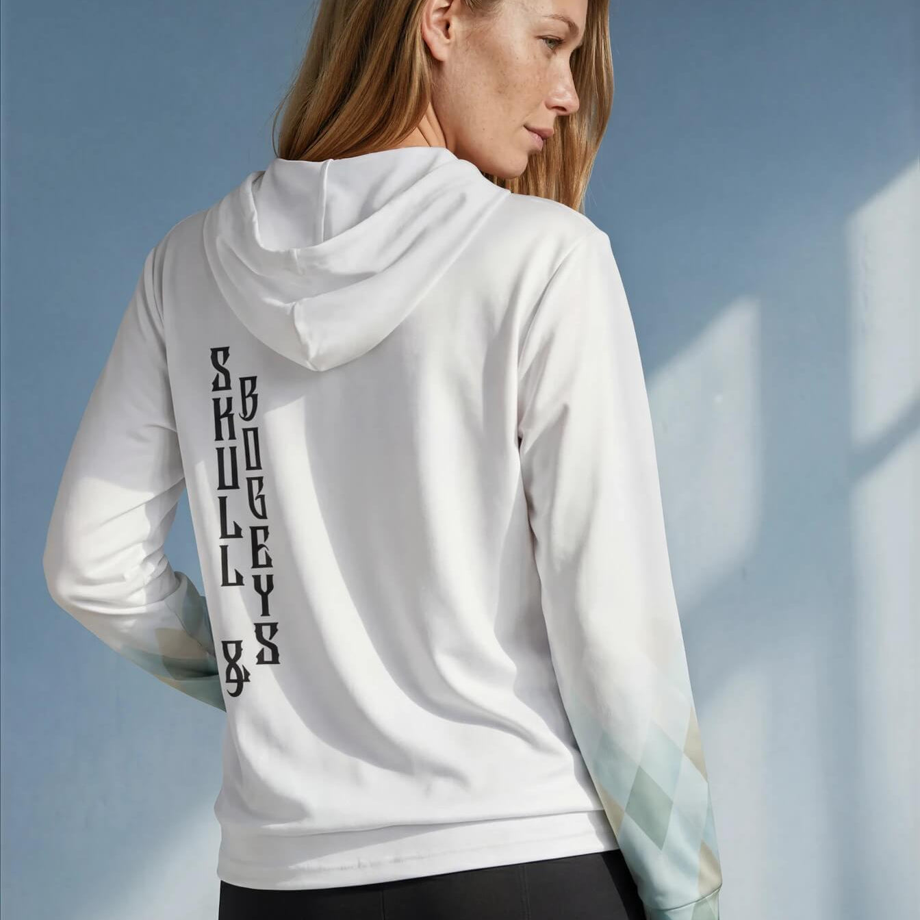 Woman wearing a white hoodie with text on the back against a blue sky.