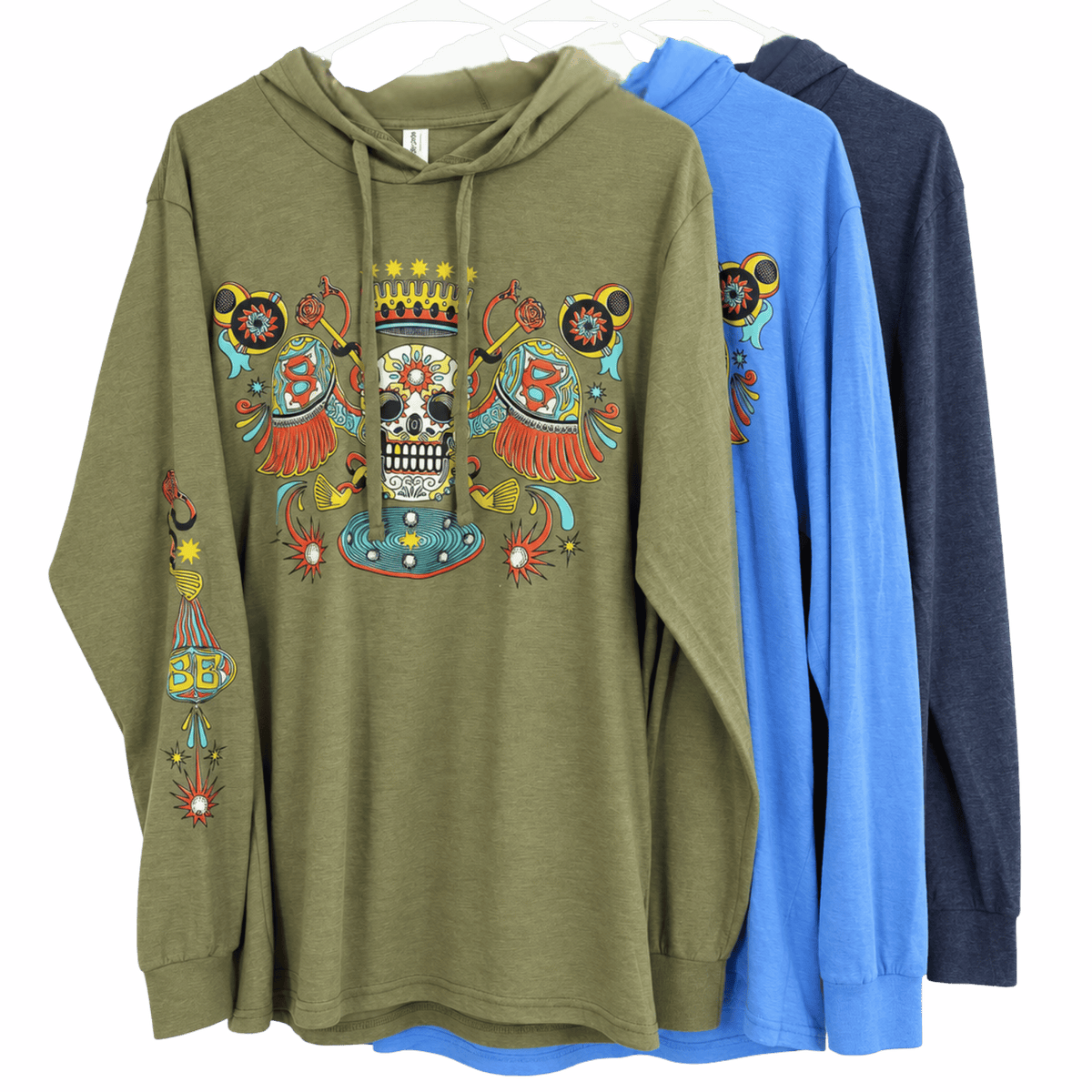 Three hooded long-sleeve shirts on hangers against a white background, showing the front design of an olive green hoodie with a colorful Day of the Dead style skull and decorative graphic. The back views show the hoodies in blue and dark navy.