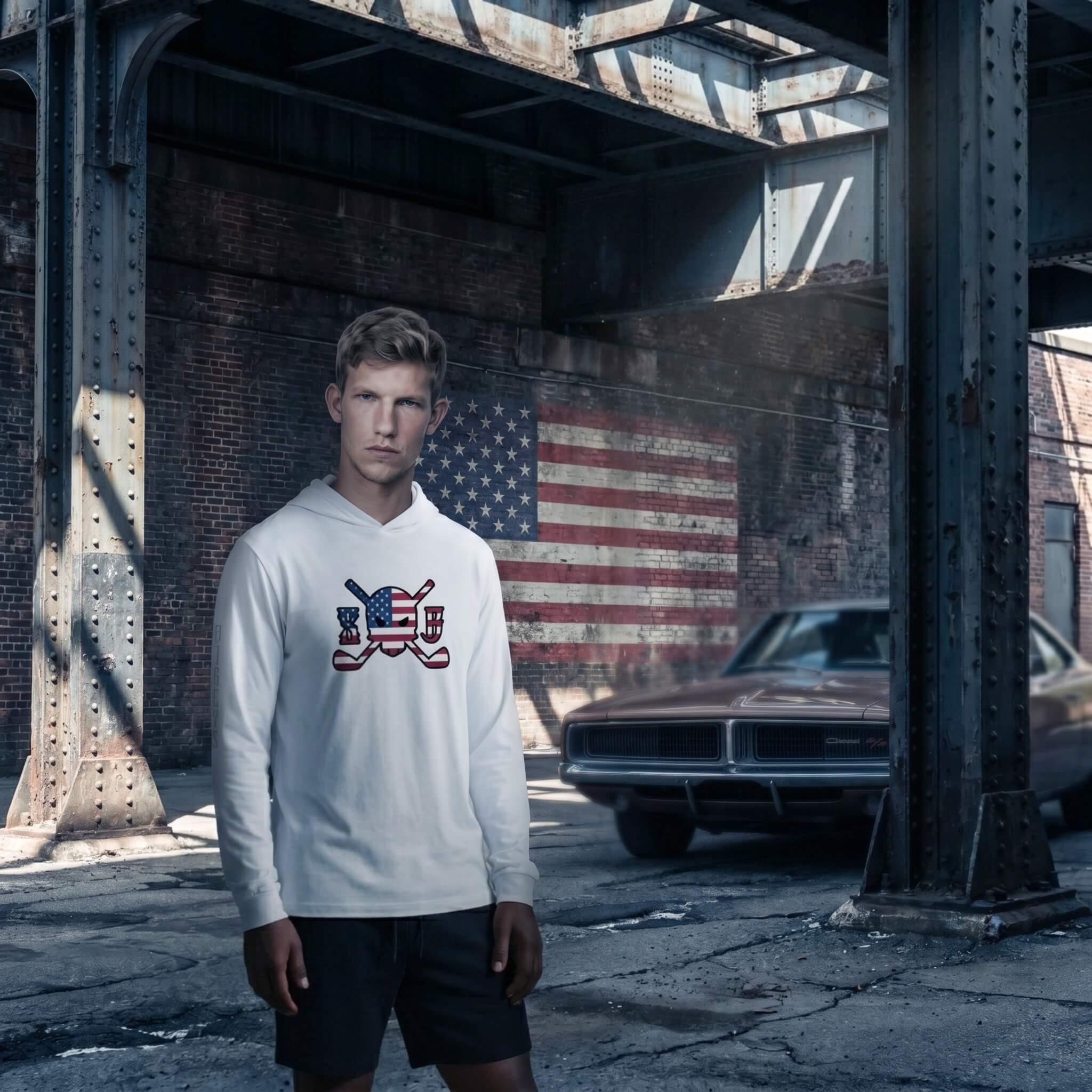 Person wearing a white hoodie with a graphic design in an urban setting with an American flag on the wall.