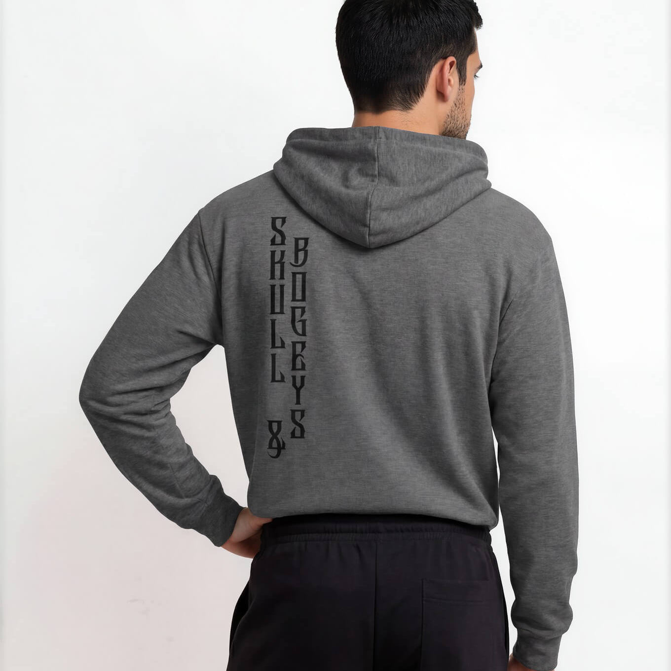 Person wearing a gray hoodie with text on the back, standing against a white background