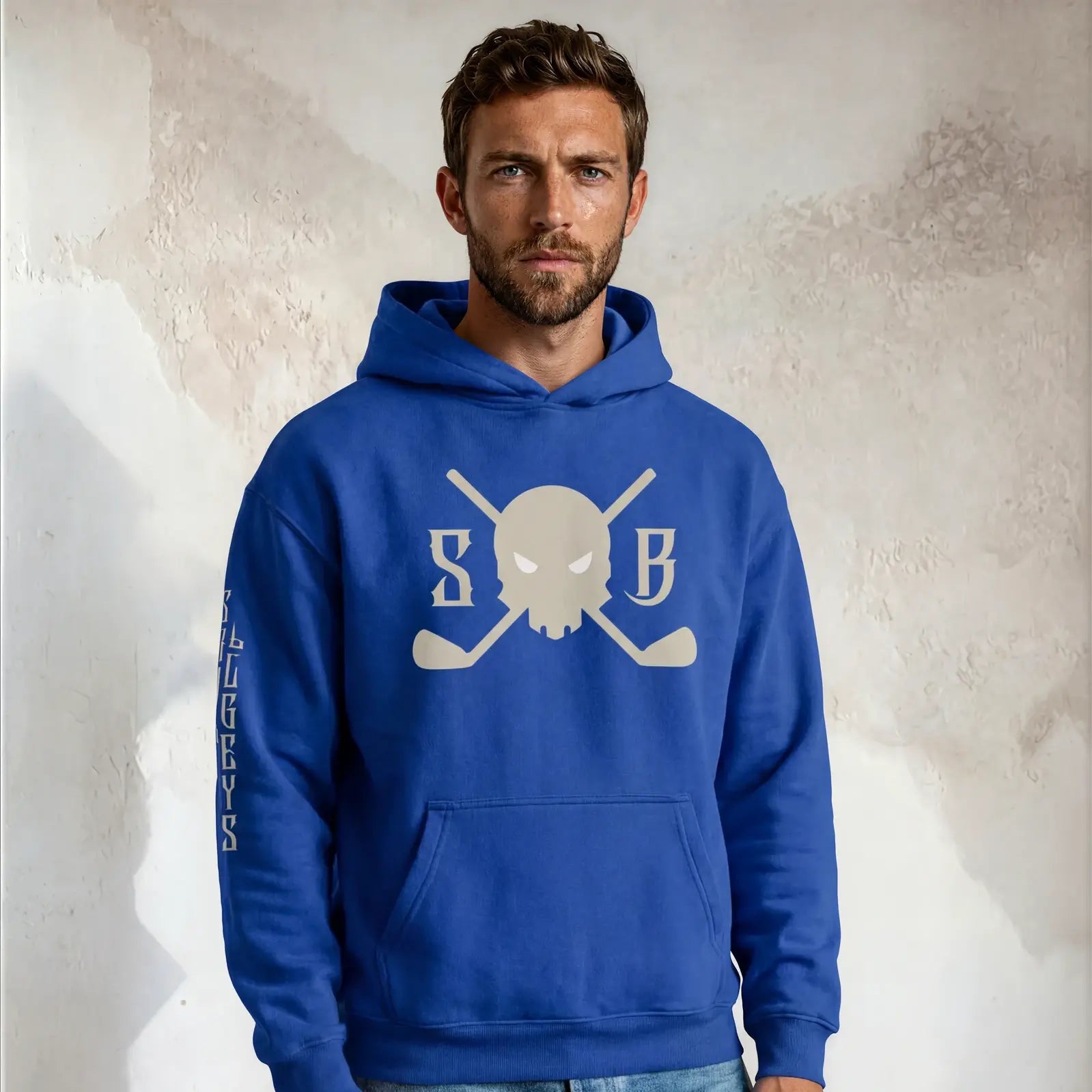 Man wearing a blue hoodie with a logo on a textured wall background