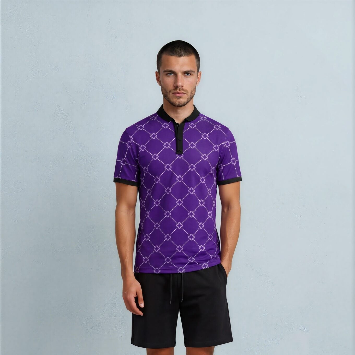 Man wearing a purple patterned polo shirt and black shorts against a light gray background