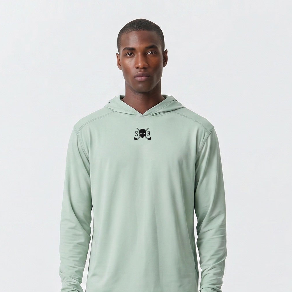 Man wearing a light green hoodie and gray pants on a white background