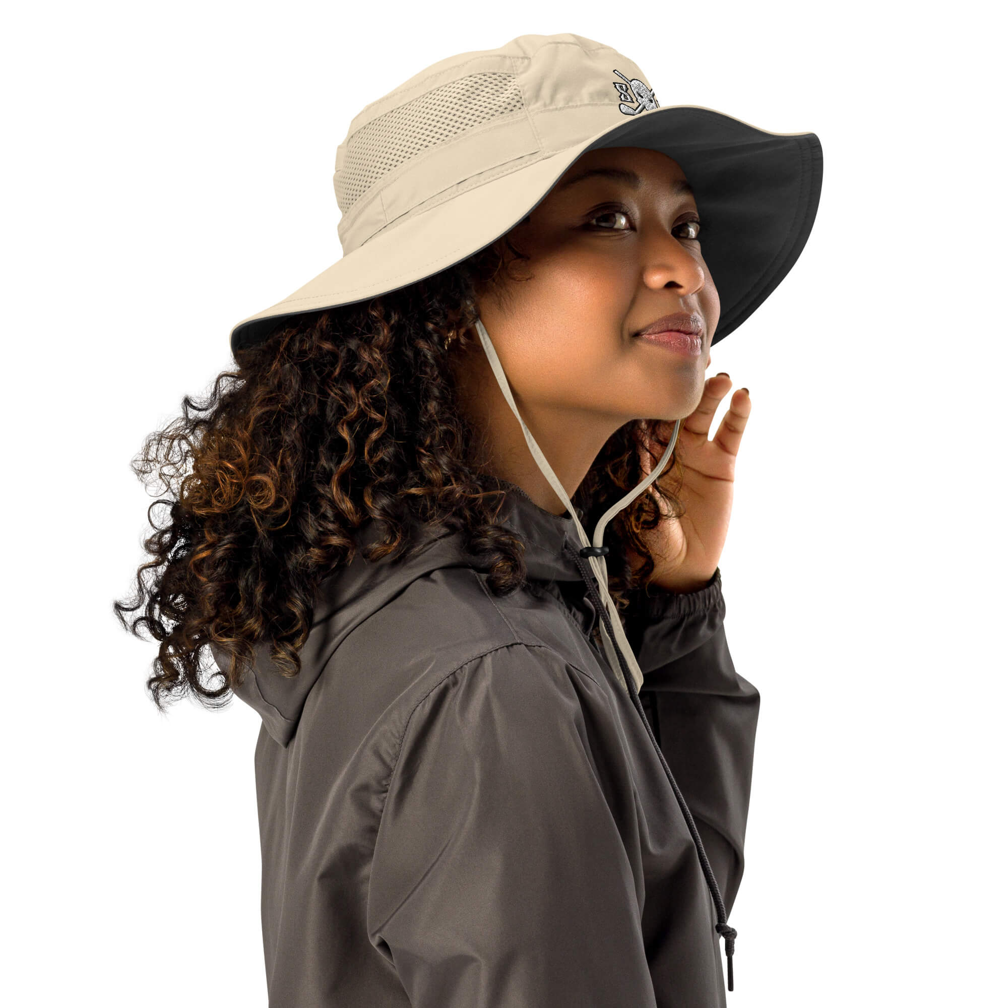 Woman wearing a Skull & Bogeys Golf Co. beige and black wide-brimmed hat with a hood, on a white background
