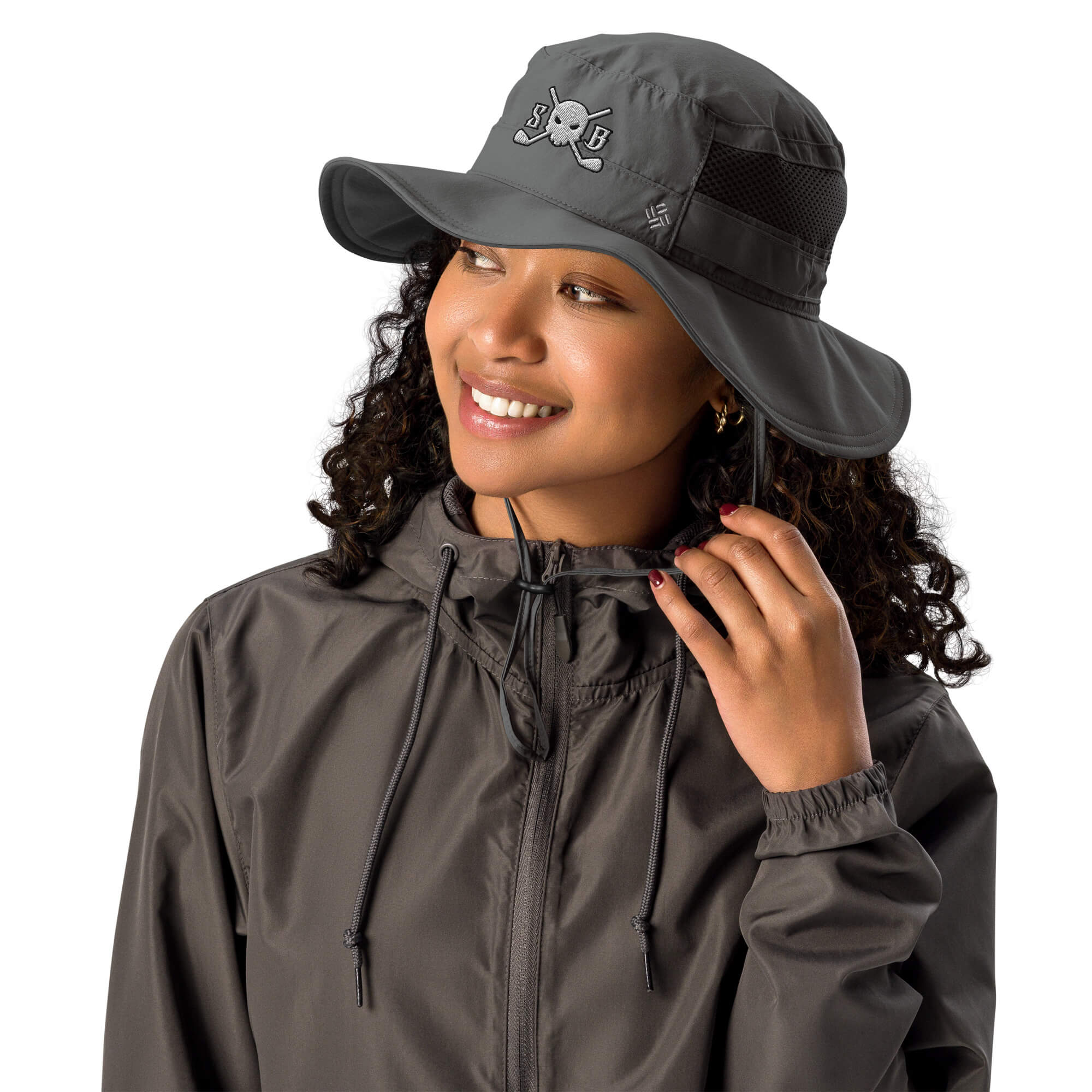 Woman wearing a Skull & Bogeys Golf Co. gray raincoat and matching hat with a visible brand logo on a white background