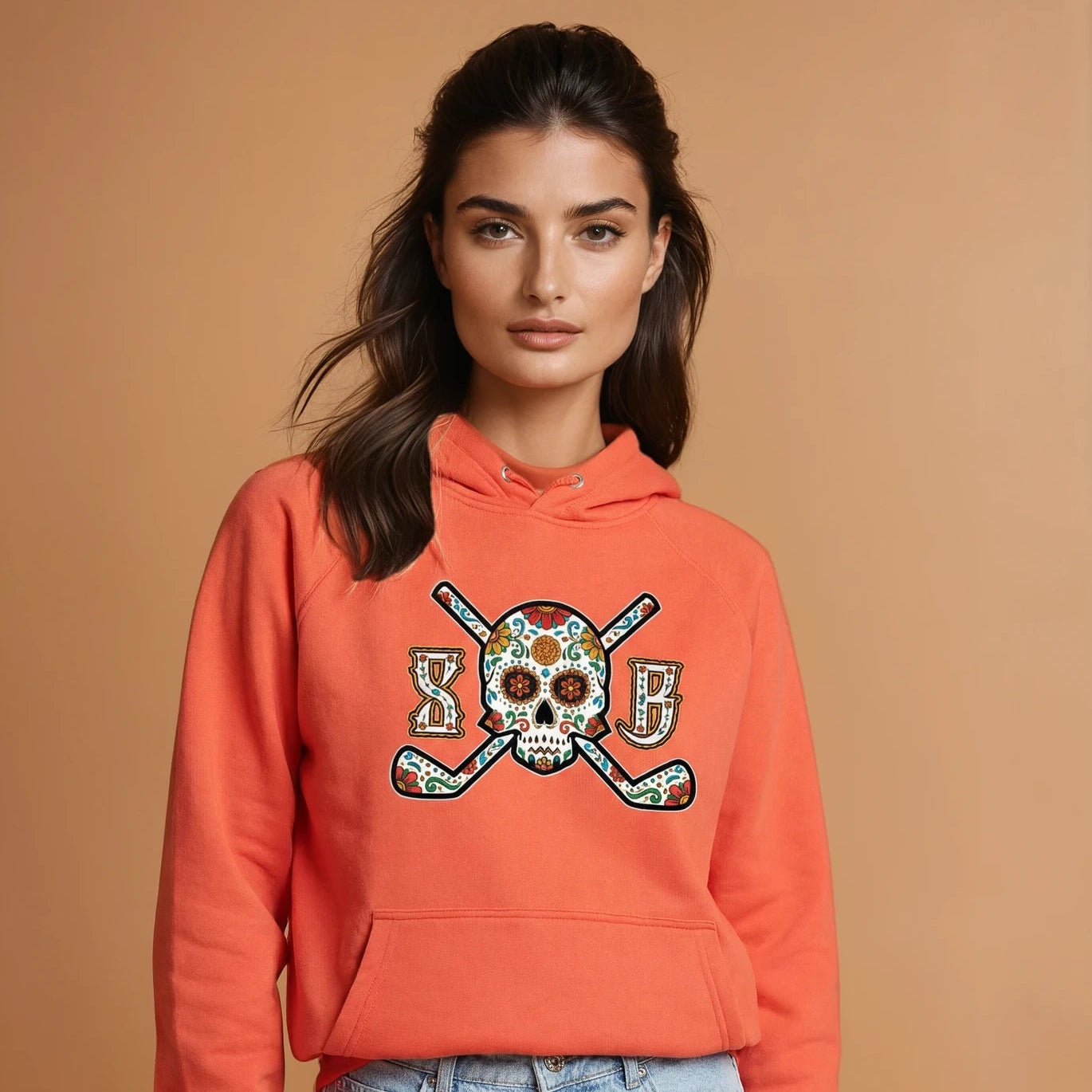 Woman wearing an orange hoodie with a skull and crossbones design on a brown background