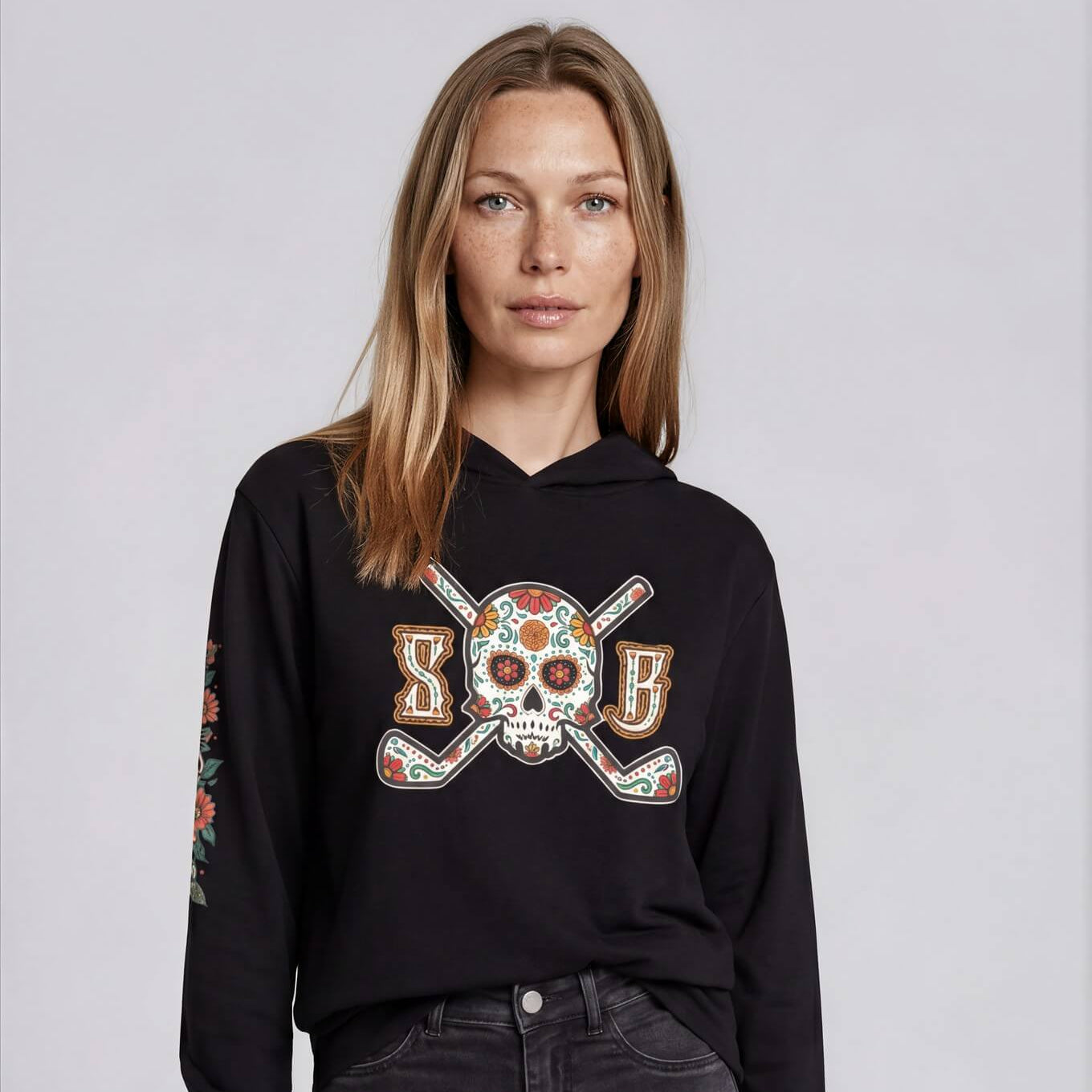 Woman wearing a black hoodie with a colorful graphic design on a light gray background