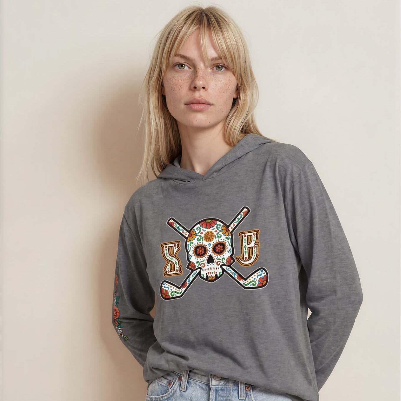 Person wearing a gray hoodie with a colorful graphic design on a beige background