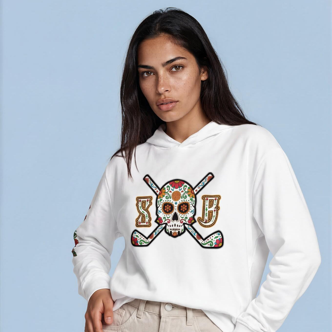 Woman wearing a white hoodie with a colorful graphic design on a light blue background